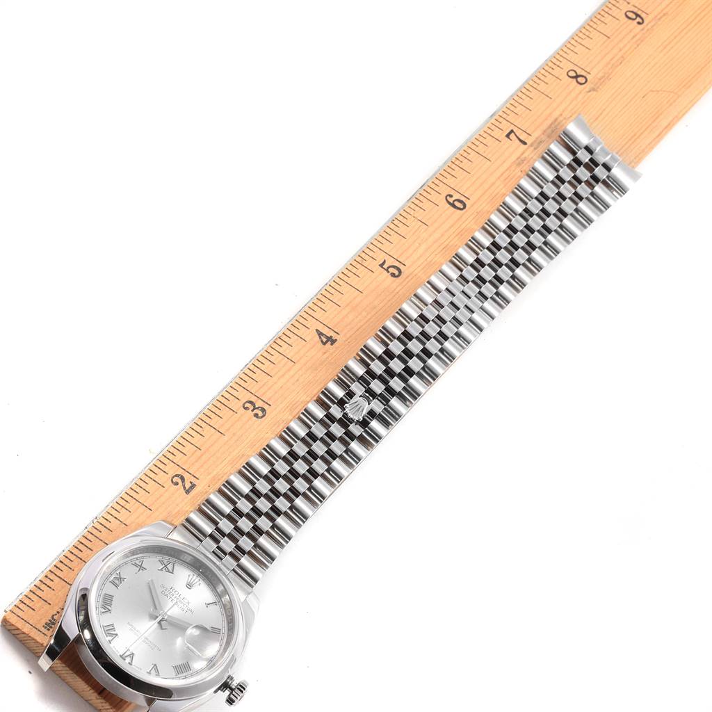 The image shows a Rolex Datejust 116200 Men's Stainless Steel Silver Dial 116200 Men's Stainless Steel Silver Dial model watch from a top-down angle, displaying its face, bracelet, and crown beside a ruler.