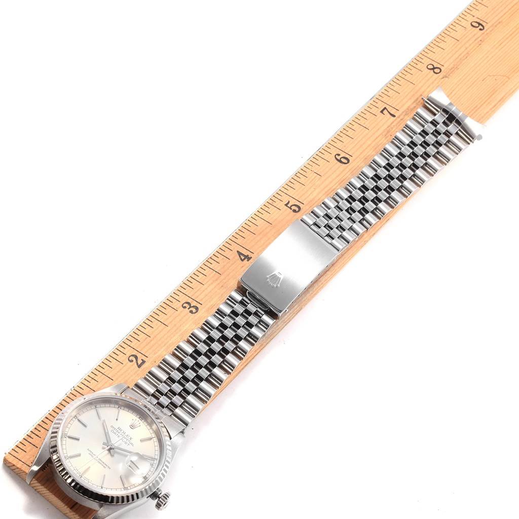 This image shows a Rolex Datejust 16234 Men's Stainless Steel Silver Dial 16234 Men's Stainless Steel Silver Dial watch laid flat alongside a wooden ruler, highlighting the bracelet and clasp.