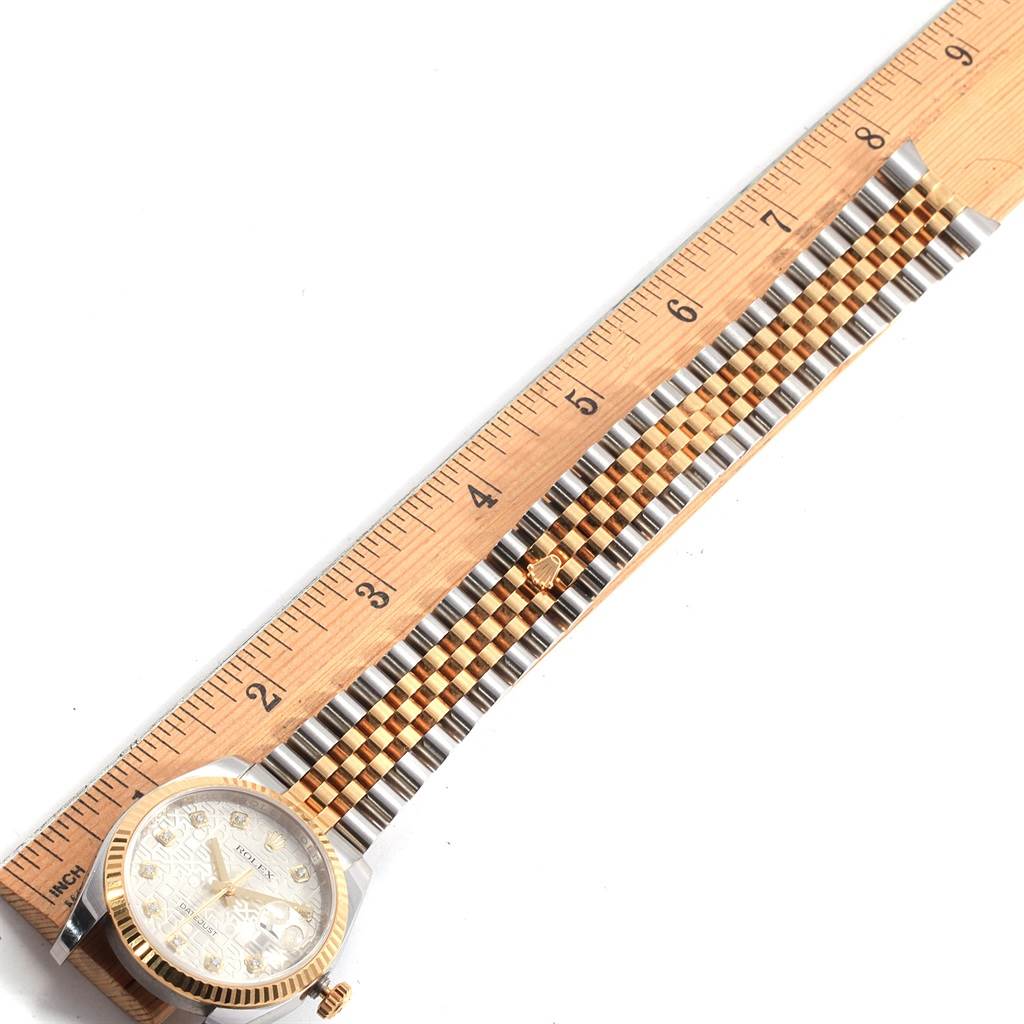The image shows a top-down view of a Rolex Datejust 116233 Men's Stainless Steel Silver Dial 116233 Men's Stainless Steel Silver Dial watch next to a wooden ruler, highlighting the watch face and bracelet.