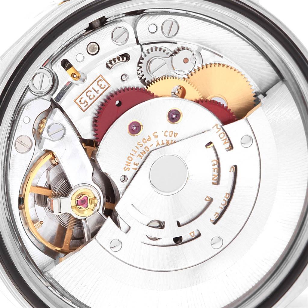 The image shows a close-up view of the movement mechanism inside a Rolex Datejust 16233 Men
s Steel and Gold (two tone) White Dial 16233 Men
s Steel and Gold (two tone) White Dial watch, highlighting gears and intricate components.