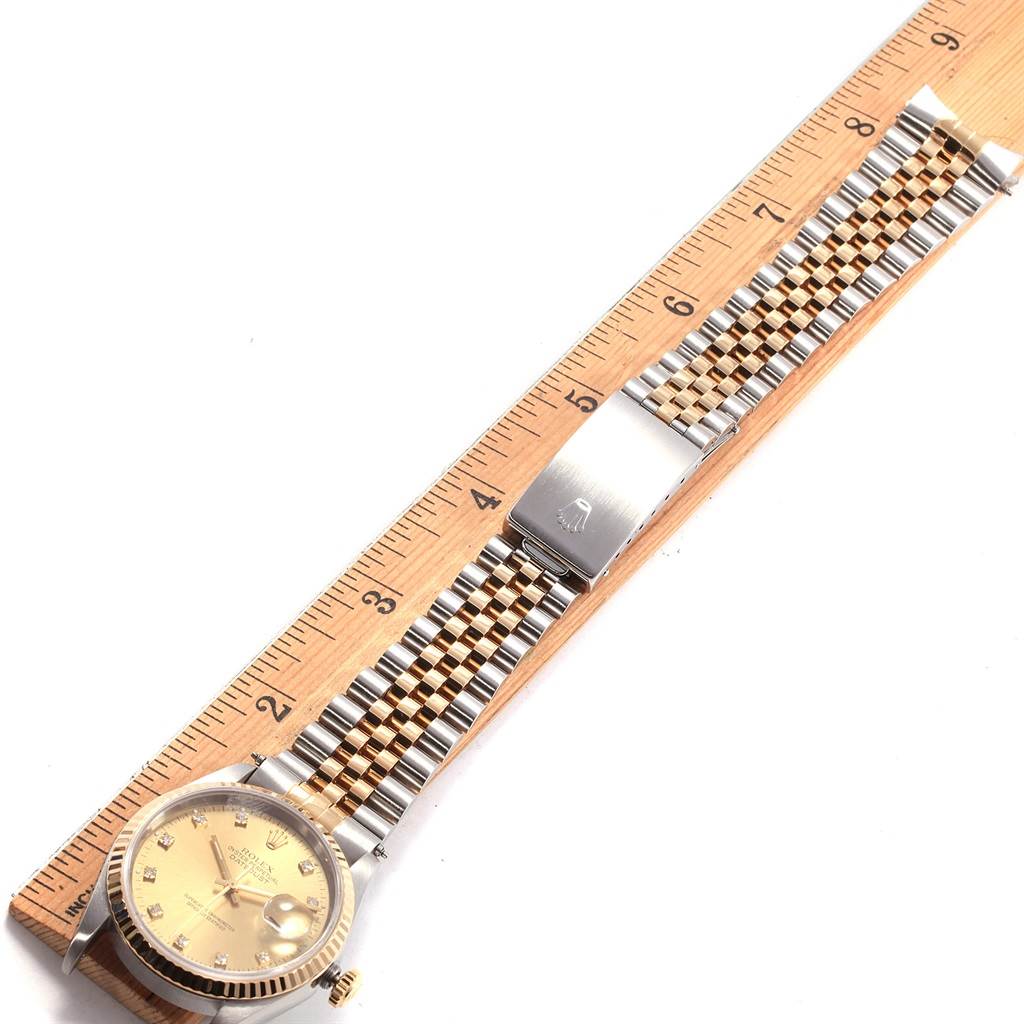 The image shows a Rolex Datejust 16233 Men's Steel and Gold (two tone) Champagne Dial 16233 Men's Steel and Gold (two tone) Champagne Dial watch laid flat on a ruler, highlighting its face and two-tone bracelet.