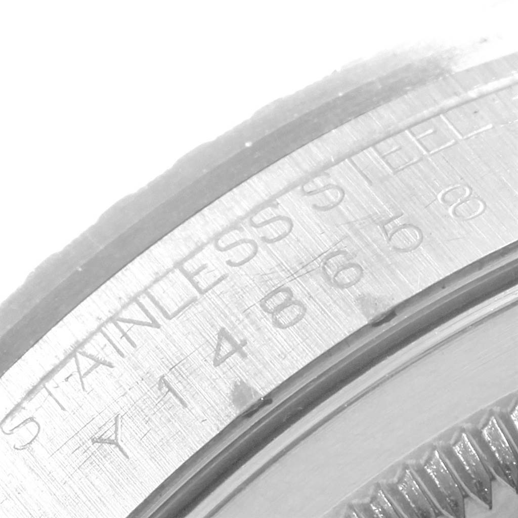 The image shows a close-up of the engraved stainless steel bezel on a Rolex Datejust 16220 Men's Stainless Steel Blue Dial 16220 Men's Stainless Steel Blue Dial watch.