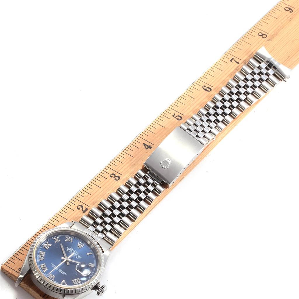 The image shows a Rolex Datejust 16220 Men's Stainless Steel Blue Dial 16220 Men's Stainless Steel Blue Dial watch horizontally aligned with a ruler, displaying its face, bracelet, and clasp.