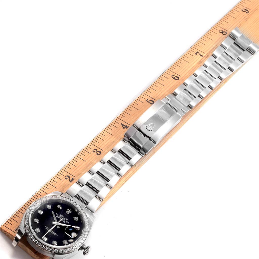 This Rolex Datejust 116244 Men's Stainless Steel Black Dial 116244 Men's Stainless Steel Black Dial watch is shown from a top-down angle, displaying the face, case, and bracelet alongside a ruler.