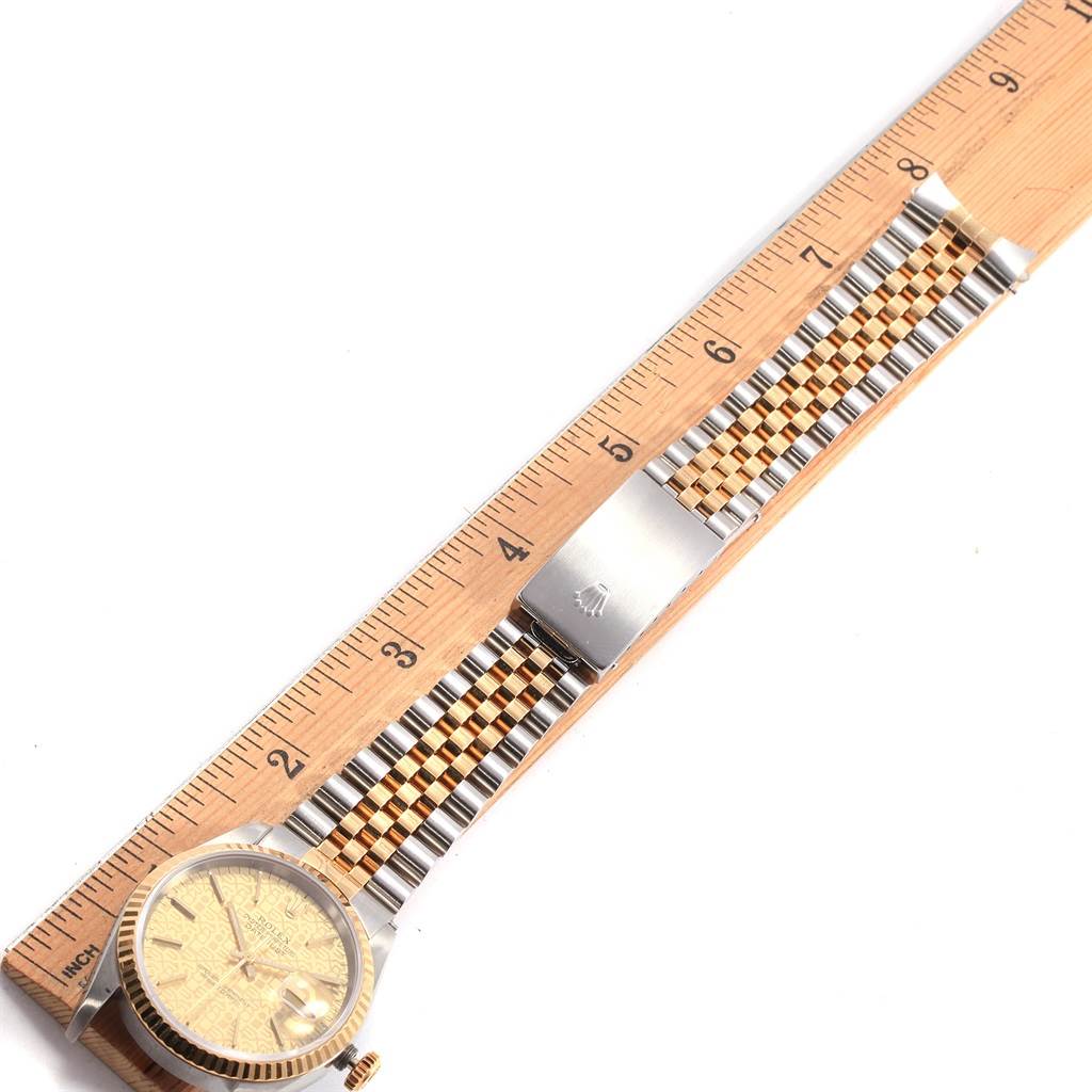 The photo shows a side view of a Rolex Datejust 16233 Men's Steel and Gold (two tone) Champagne Dial 16233 Men's Steel and Gold (two tone) Champagne Dial watch, highlighting its dial, bracelet, and clasp against a ruler.