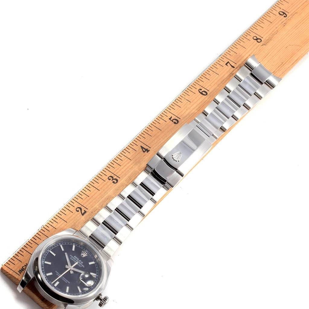 The image shows a Rolex Datejust 116200 Men's Stainless Steel Black Dial 116200 Men's Stainless Steel Black Dial watch with a ruler measuring its length, displaying the face and the full metal bracelet.