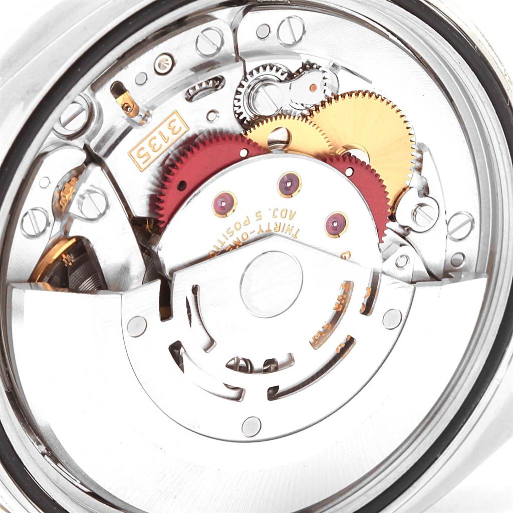 The image shows a close-up of the movement mechanism inside a Rolex Datejust 116200 Men's Stainless Steel Black Dial 116200 Men's Stainless Steel Black Dial watch, highlighting the gears and components.