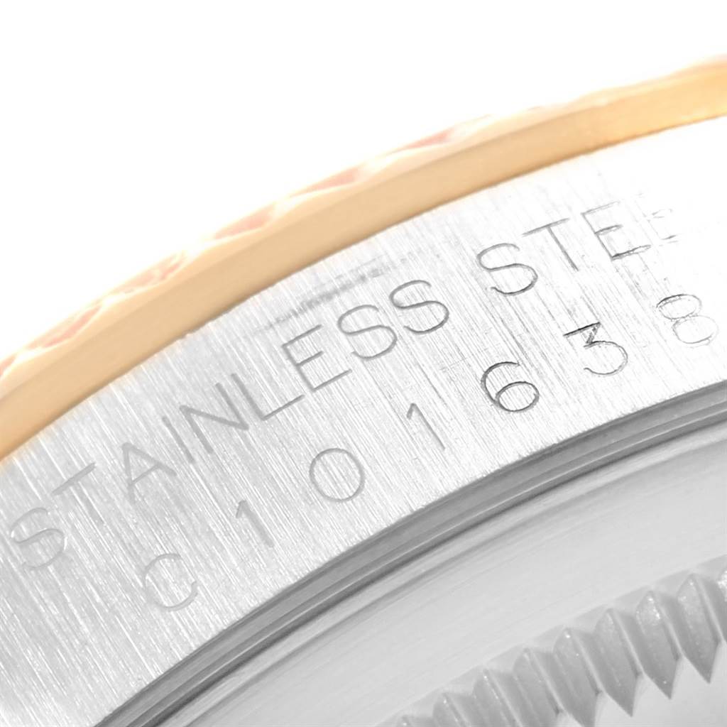 This macro shot of a Rolex Datejust 16233 Steel and Gold (two tone) Champagne Dial 16233 Steel and Gold (two tone) Champagne Dial features the engraved stainless steel casing and part of the fluted bezel.