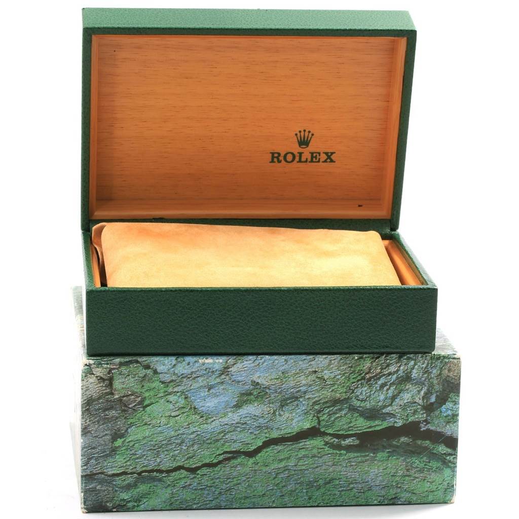The image shows an open Rolex Datejust 16233 Men's Steel and Gold (two tone) Blue Dial 16233 Men's Steel and Gold (two tone) Blue Dial watch box with a green exterior, a wooden interior, and a suede pillow inside.