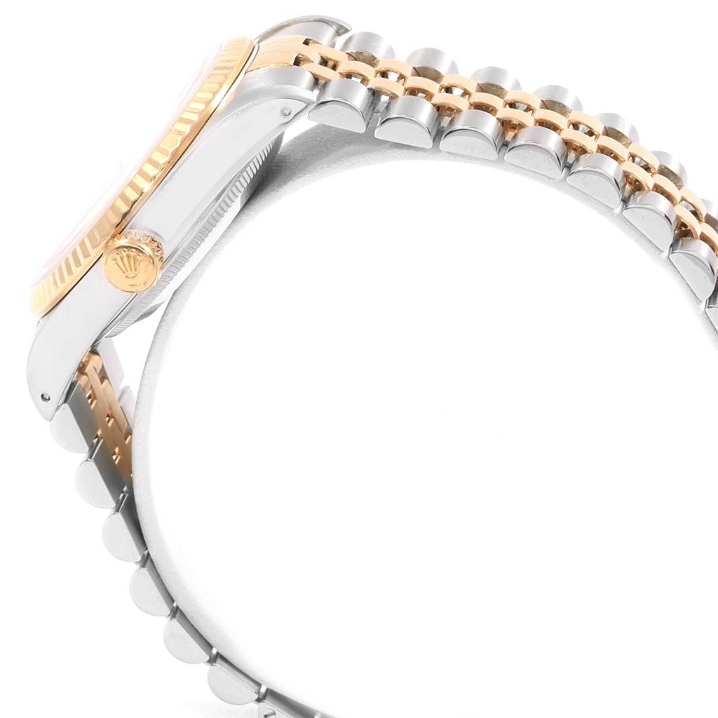 The image shows a side view of a Rolex Datejust 16233 Men's Steel and Gold (two tone) Blue Dial 16233 Men's Steel and Gold (two tone) Blue Dial, highlighting its crown, fluted bezel, and two-tone bracelet.