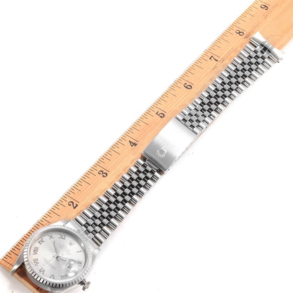 The Rolex Datejust 16220 Men's Stainless Steel Silver Dial 16220 Men's Stainless Steel Silver Dial is shown from a top-down view displaying the watch face, band, and a measurement ruler beside it.