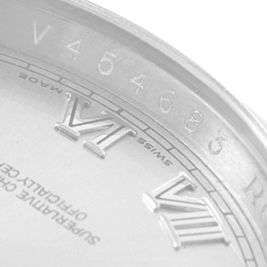 The image shows a close-up of the dial and rehaut of a Rolex Datejust 116200 Men's Stainless Steel Silver Dial 116200 Men's Stainless Steel Silver Dial, highlighting Roman numerals and an engraved serial number.