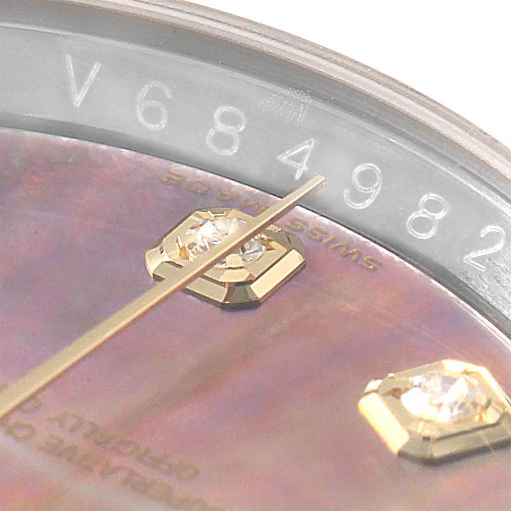 This is a close-up of a Rolex Datejust 116243 Men's Stainless Steel Mother of Pearl Dial 116243 Men's Stainless Steel Mother of Pearl Dial model's dial, showcasing the serial number, gemstone markers, and part of the minute hand.