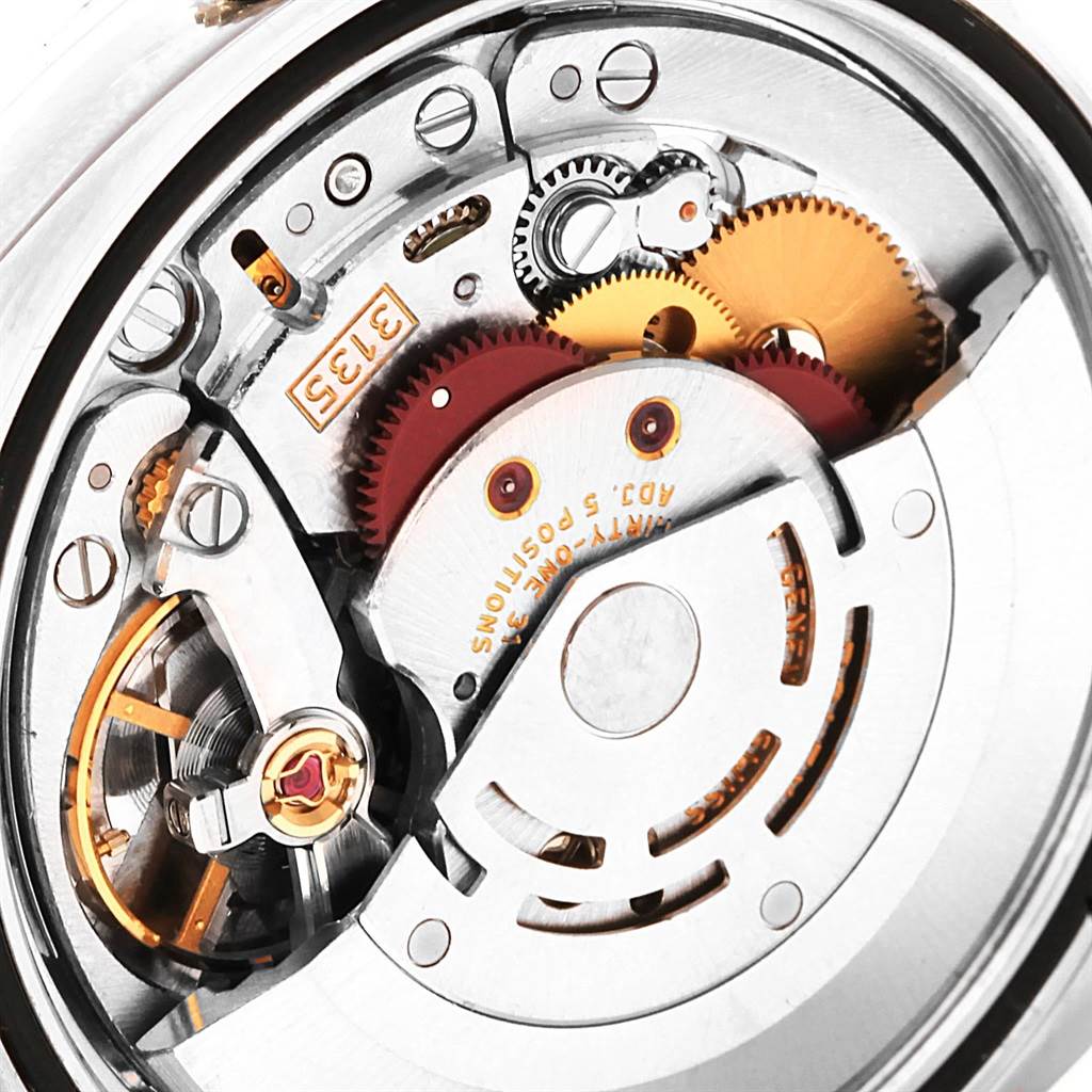 The image shows a close-up of the internal mechanism of a Rolex Datejust 116234 Men's Stainless Steel Blue Dial 116234 Men's Stainless Steel Blue Dial watch, highlighting gears and movement components.