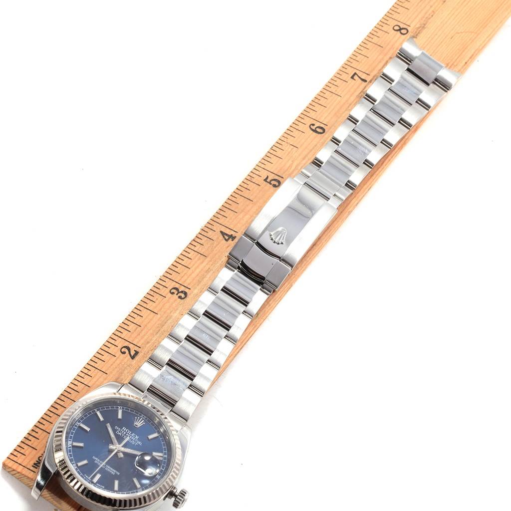 The Rolex Datejust 116234 Men's Stainless Steel Blue Dial 116234 Men's Stainless Steel Blue Dial watch is shown laid flat with its bracelet extended alongside a ruler.