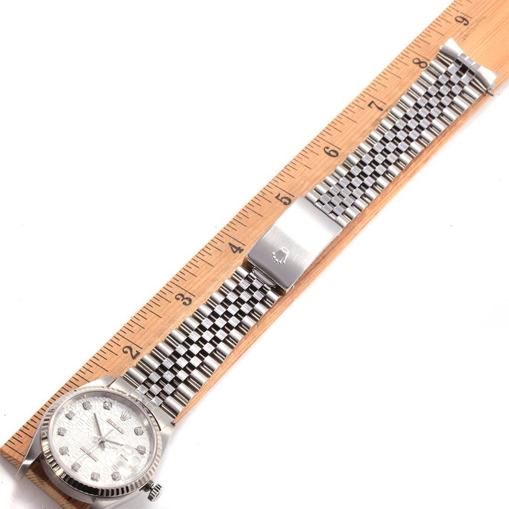 The Rolex Datejust 16234 Men
s Stainless Steel Silver Dial 16234 Men
s Stainless Steel Silver Dial watch is shown flat alongside a ruler, displaying its watch face, bezel, and metal bracelet.