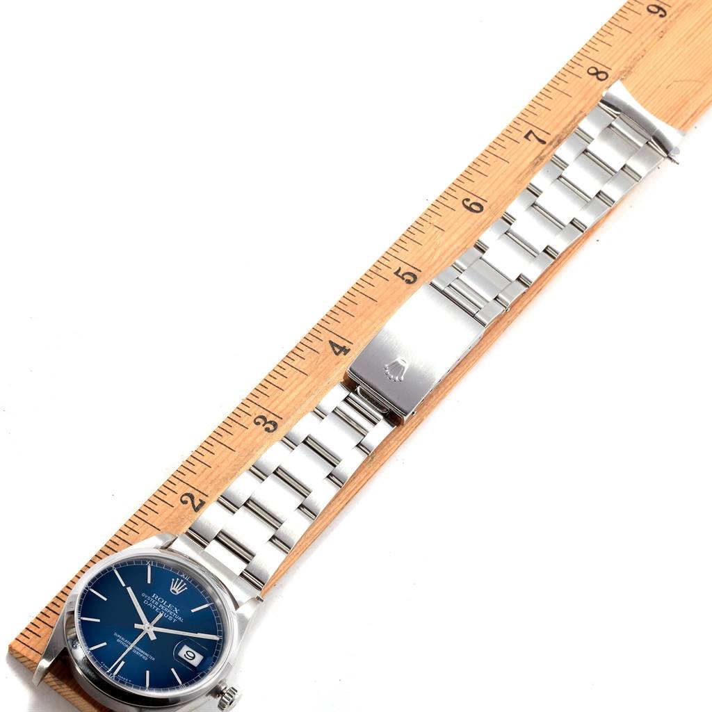 The image shows a Rolex Datejust 16200 Men's Stainless Steel Blue Dial 16200 Men's Stainless Steel Blue Dial watch laid flat next to a ruler, displaying its face, bracelet, and clasp.