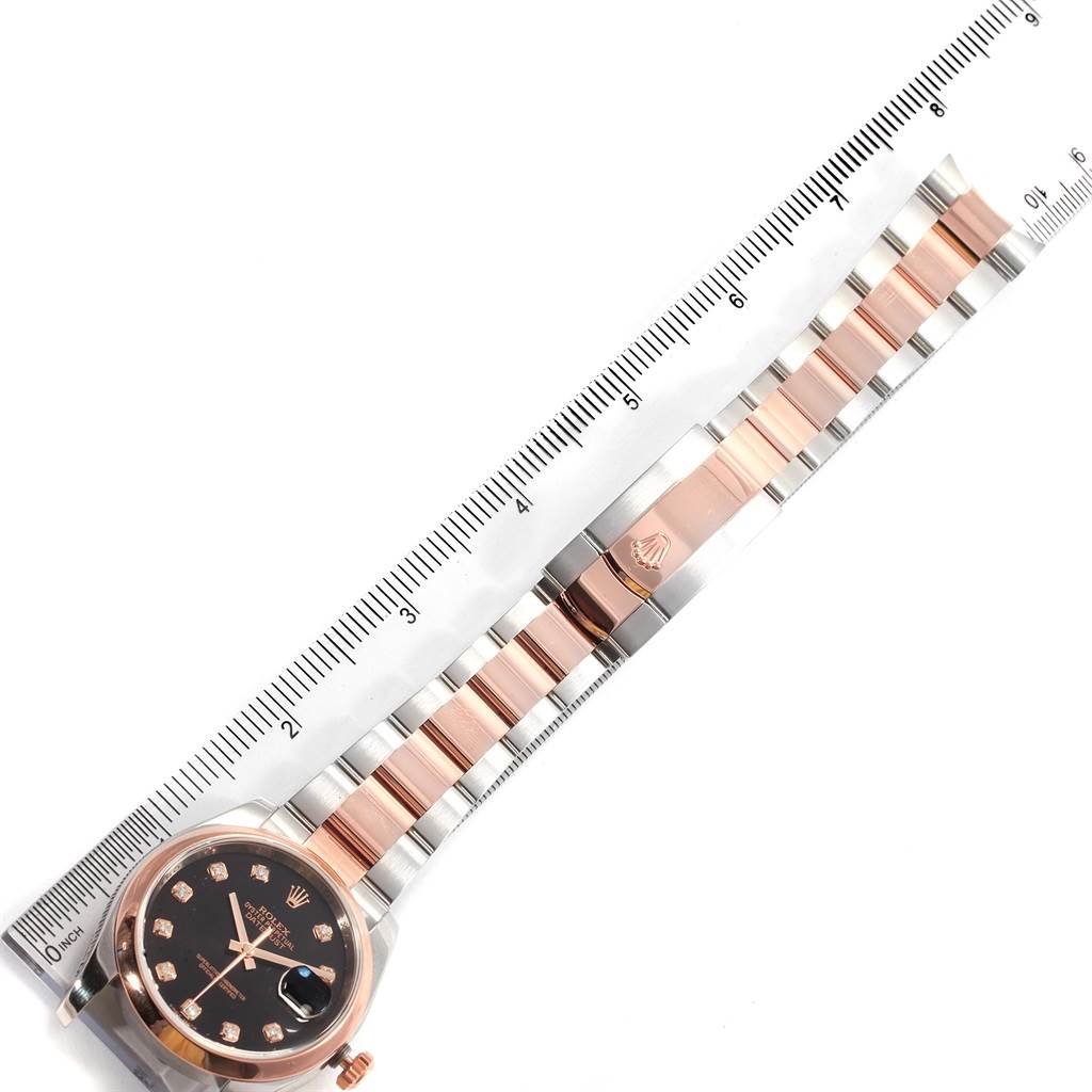 The image shows an overhead view of a Rolex Datejust 116201 Men's Steel and Gold (two tone) Black Dial 116201 Men's Steel and Gold (two tone) Black Dial model watch, highlighting the face, bezel, and bracelet alongside a ruler.