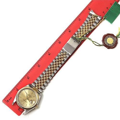 The image shows a Rolex Datejust 16233 Men's Stainless Steel Champagne Dial 16233 Men's Stainless Steel Champagne Dial watch laid flat next to a ruler, displaying its face, bracelet, and Rolex tag.