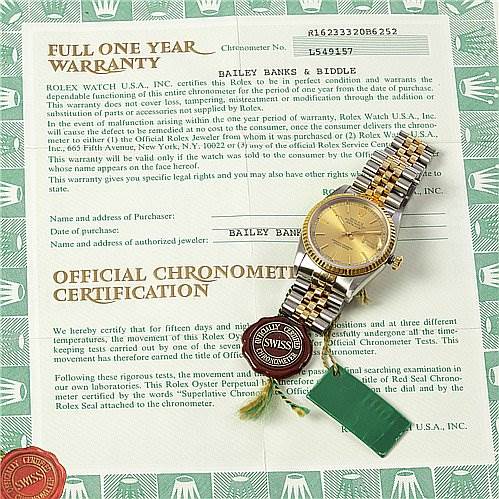 The image shows a Rolex Datejust 16233 Men's Stainless Steel Champagne Dial 16233 Men's Stainless Steel Champagne Dial watch placed on its warranty and certification papers, including tags and seals.
