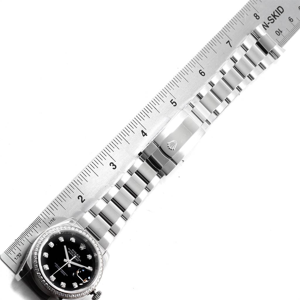 The image shows the black dial and bracelet of a Rolex Datejust 116244 Men
s Stainless Steel Black Dial 116244 Men
s Stainless Steel Black Dial watch, laid flat alongside a ruler.