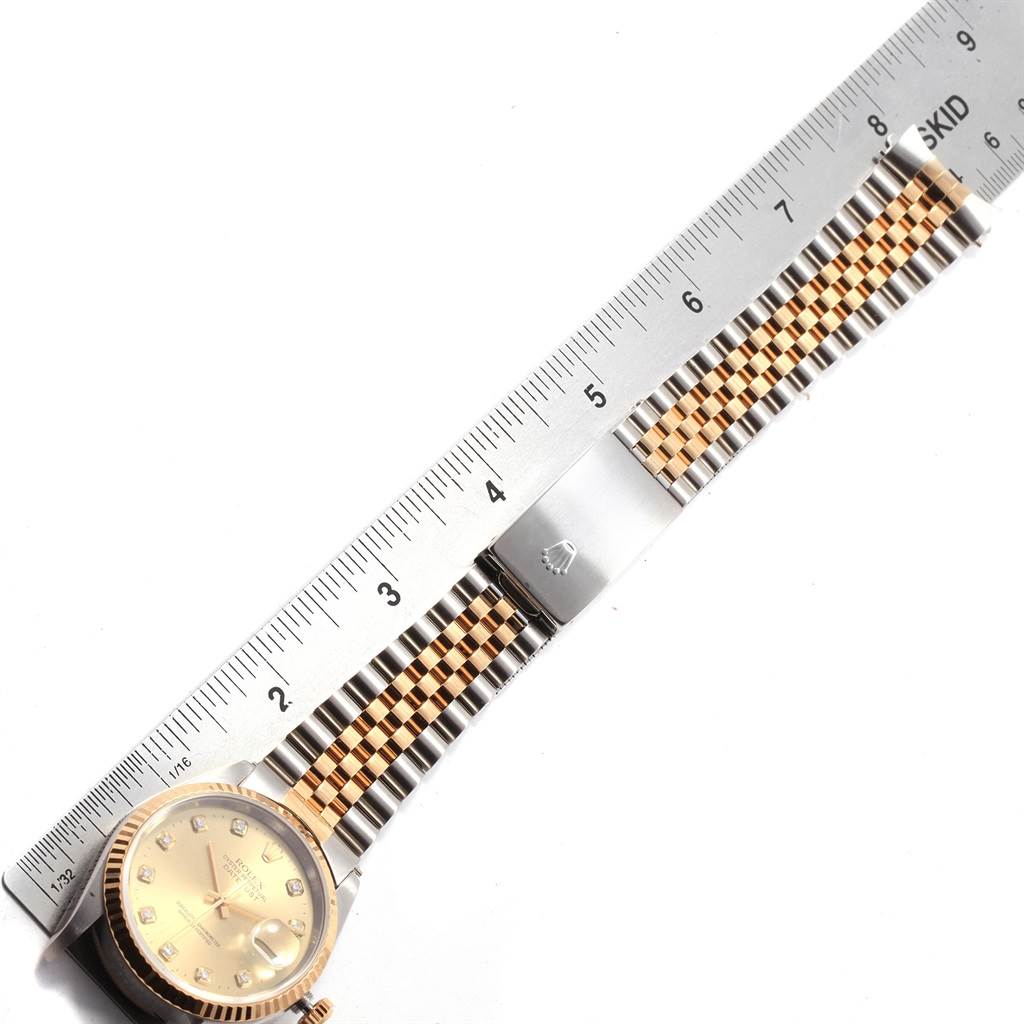 The image shows a Rolex Datejust 16233 Men's Steel and Gold (two tone) Silver Dial 16233 Men's Steel and Gold (two tone) Silver Dial watch with a two-tone bracelet next to a ruler for measurement.