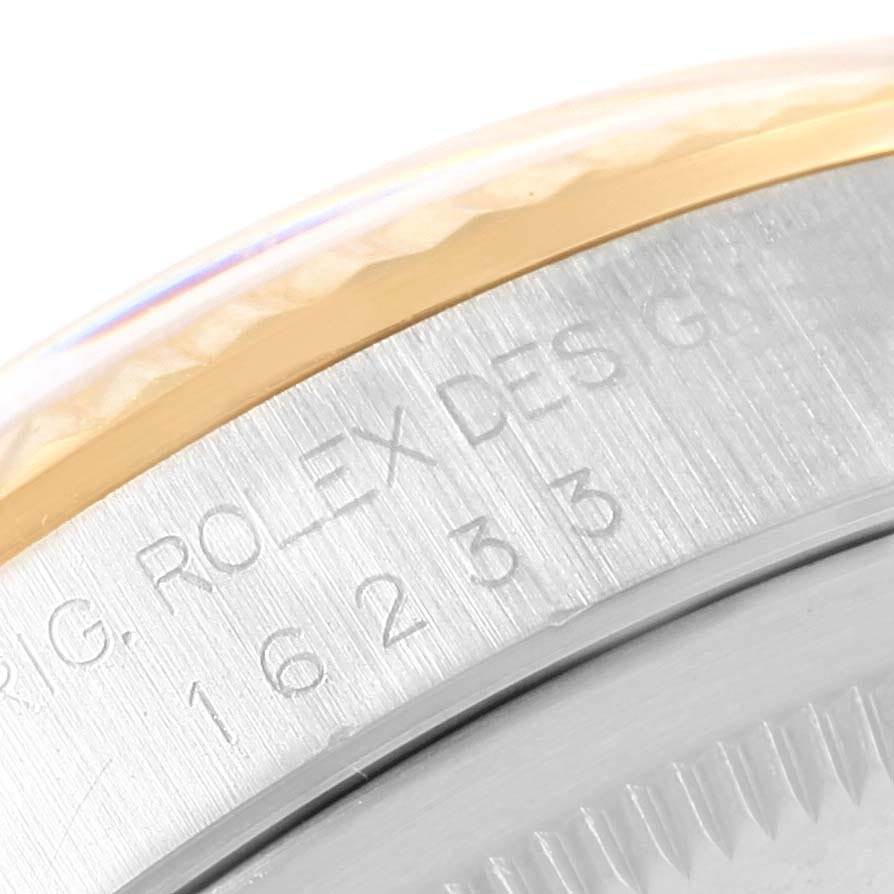 The image shows the side view of a Rolex Datejust 16233 Men's Steel and Gold (two tone) Silver Dial 16233 Men's Steel and Gold (two tone) Silver Dial watch with inscriptions on the metal surface and part of the bezel.