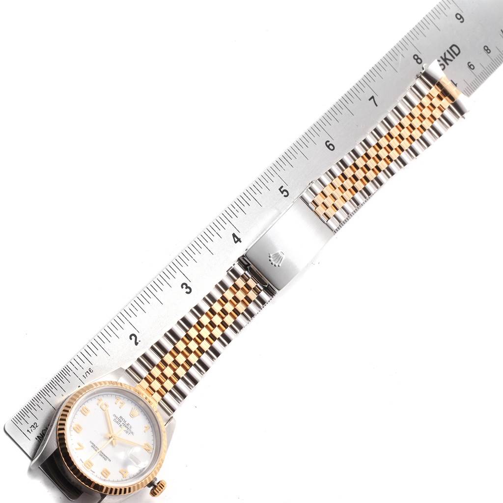The image shows a Rolex Datejust 16233 Men's Steel and Gold (two tone) White Dial 16233 Men's Steel and Gold (two tone) White Dial watch laid flat with its band extended alongside a ruler, highlighting the dial and bracelet.