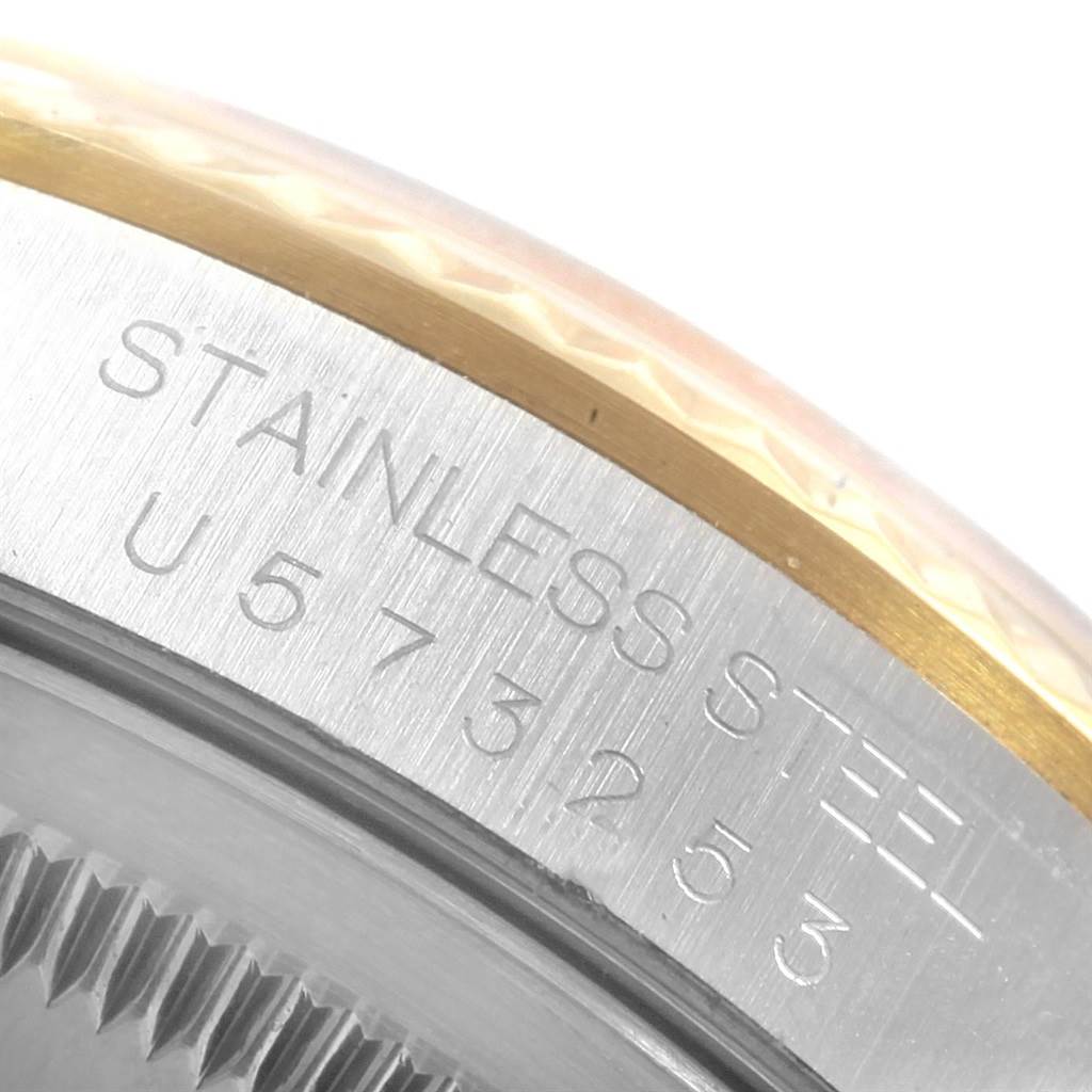 The image shows a close-up of the side of a Rolex Datejust 16233 Men's Steel and Gold (two tone) White Dial 16233 Men's Steel and Gold (two tone) White Dial watch case, revealing "STAINLESS STEEL" and part of the serial number.