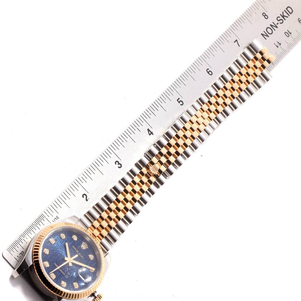 The image shows a Rolex Datejust 116233 Men
s Stainless Steel Blue Dial 116233 Men
s Stainless Steel Blue Dial watch, highlighting its face, ruler, and two-tone bracelet at an angled view.
