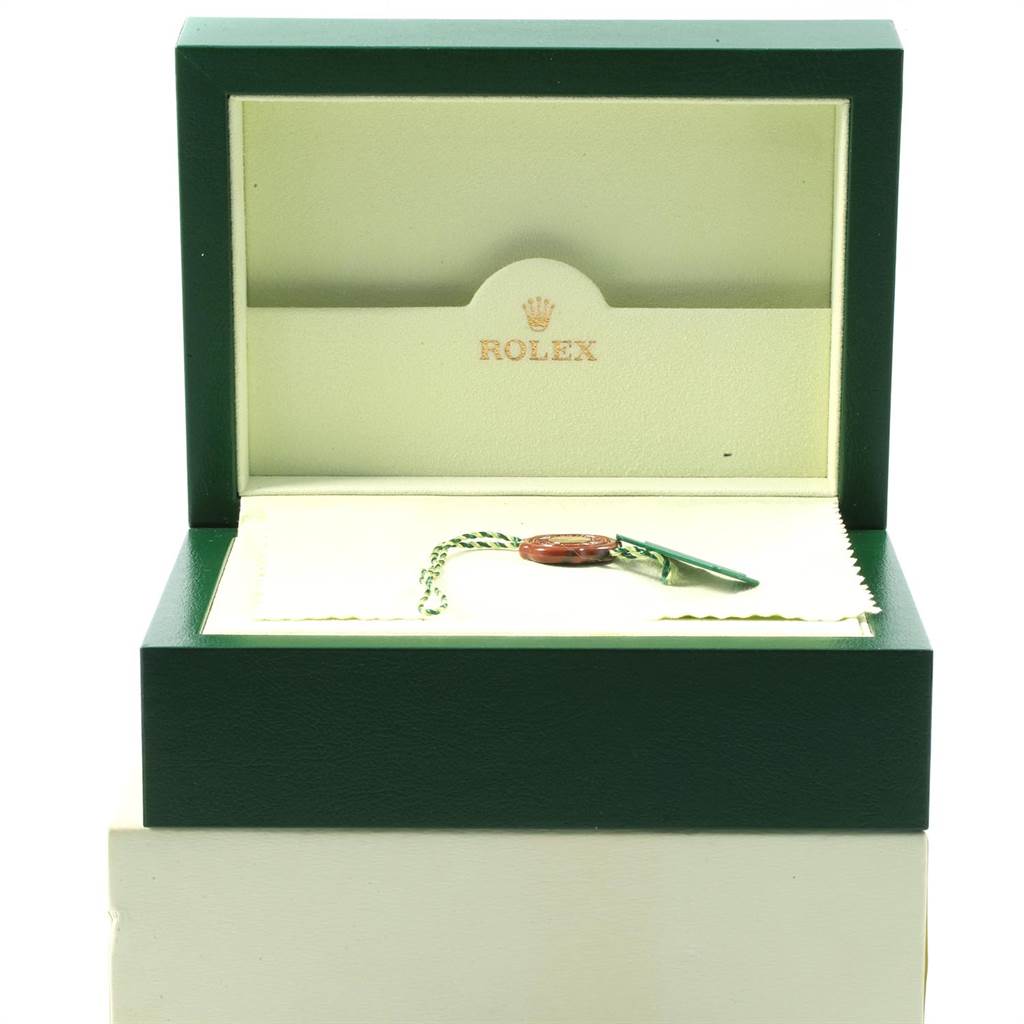The image shows an open green Rolex box for the Datejust model, containing a hang tag and a cleaning cloth.