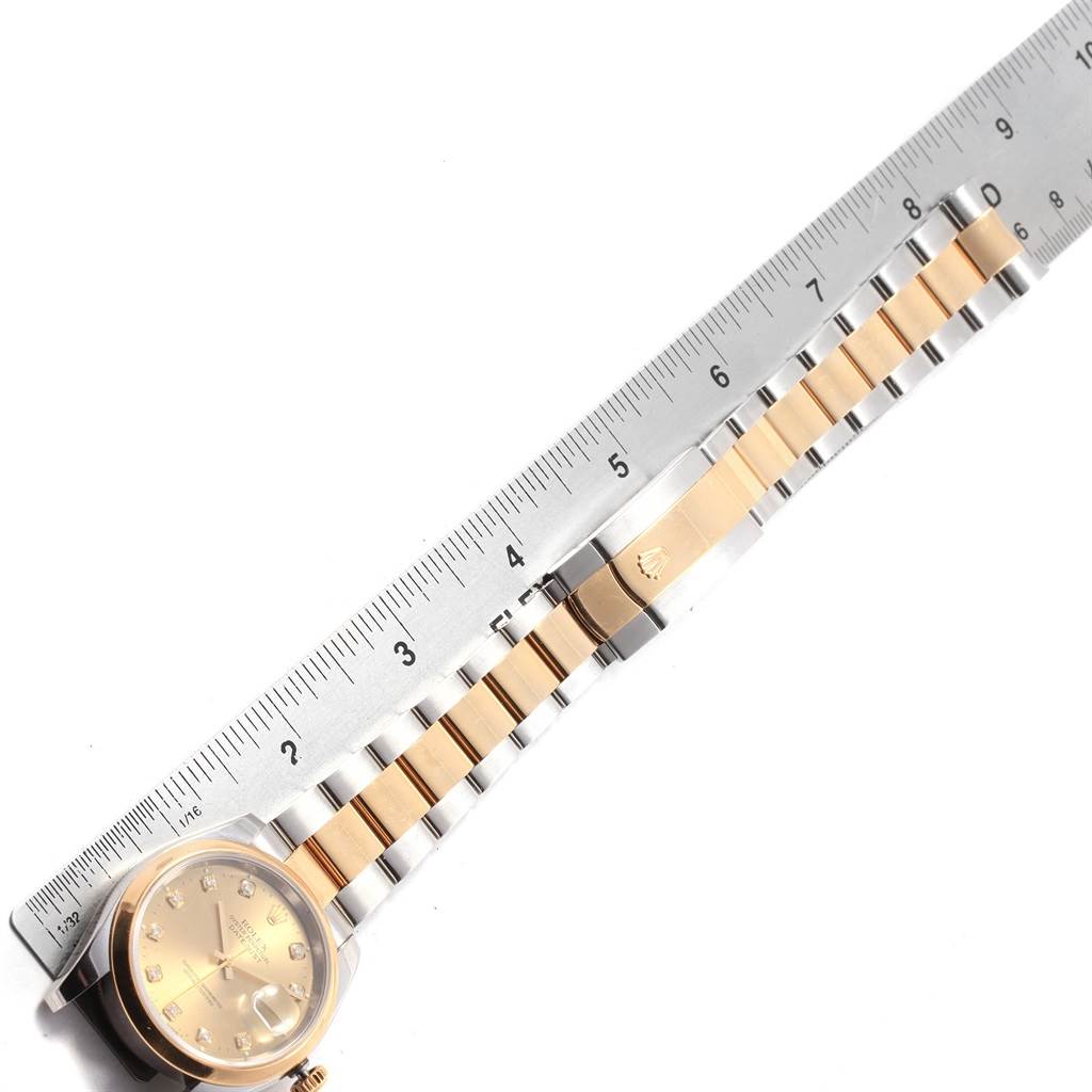 The image shows a top view of a Rolex Datejust 116203 Men's Stainless Steel Champagne Dial 116203 Men's Stainless Steel Champagne Dial watch with a measurement ruler placed along its two-tone bracelet and clasp.
