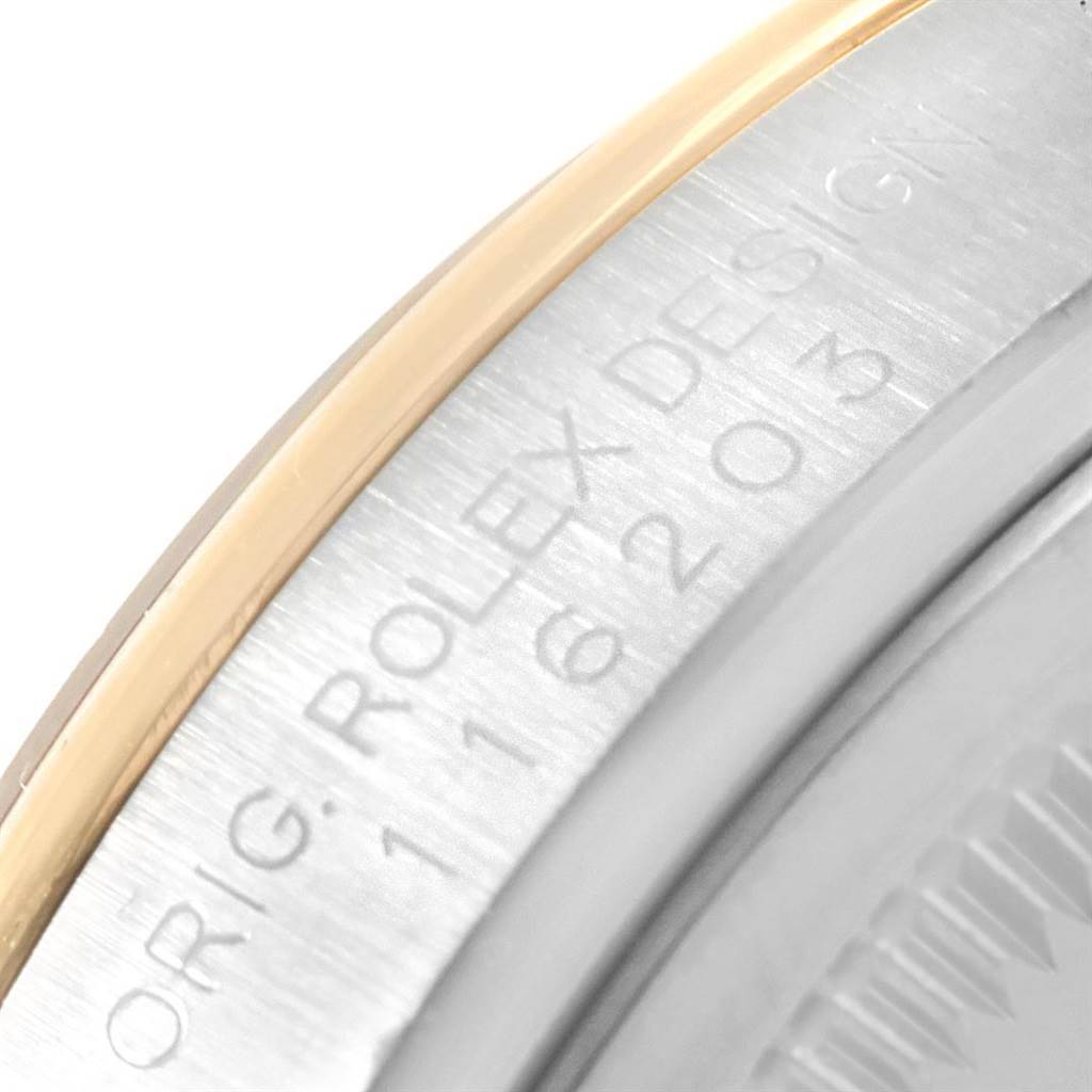 This close-up of a Rolex Datejust 116203 Men's Stainless Steel Champagne Dial 116203 Men's Stainless Steel Champagne Dial watch shows the edge of the bezel and part of the engraved case side.