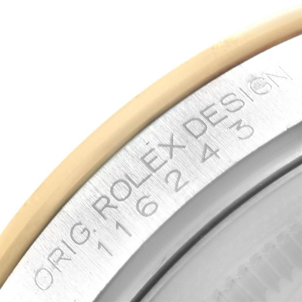 The image shows a close-up of the bezel and inner rim of a Rolex Datejust 116243 Men
s Stainless Steel Brown Dial 116243 Men
s Stainless Steel Brown Dial watch, highlighting the engraved "Rolex Design" text.