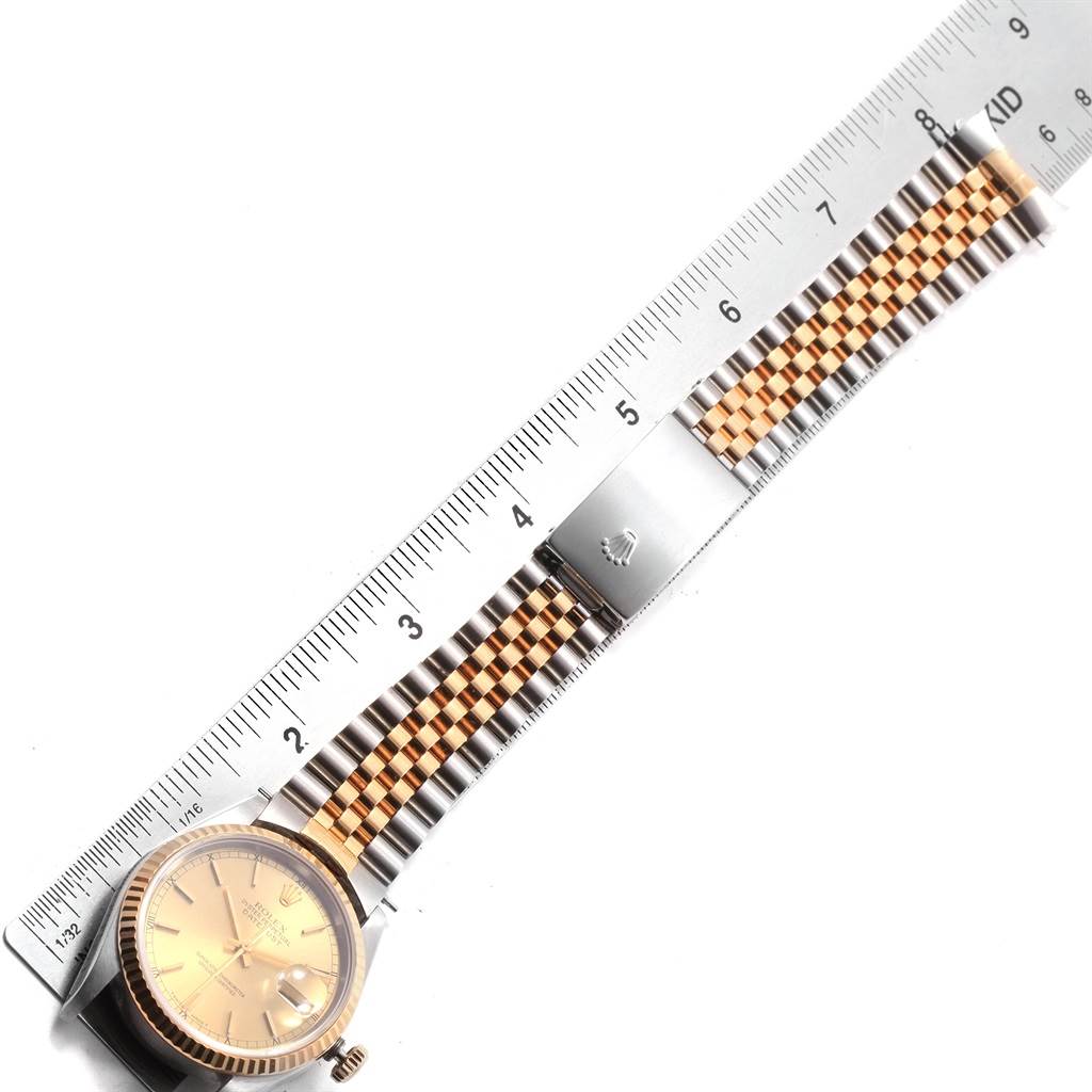 The image shows a Rolex Datejust 16233 Men's Steel and Gold (two tone) Champagne Dial 16233 Men's Steel and Gold (two tone) Champagne Dial watch, highlighting its face, bezel, and Jubilee bracelet against a ruler.