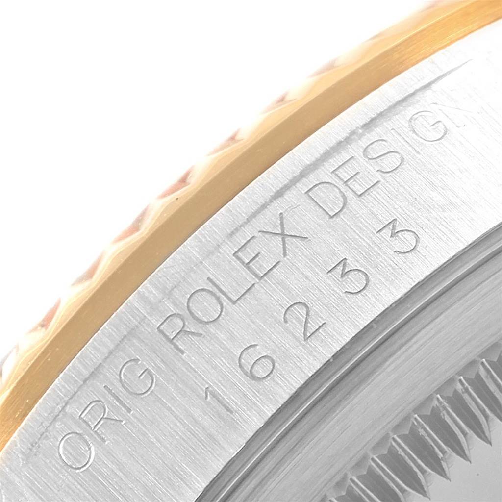 The image shows a close-up angle of the side of a Rolex Datejust 16233 Men's Steel and Gold (two tone) White Dial 16233 Men's Steel and Gold (two tone) White Dial watch case with engraved text and bezel detail.