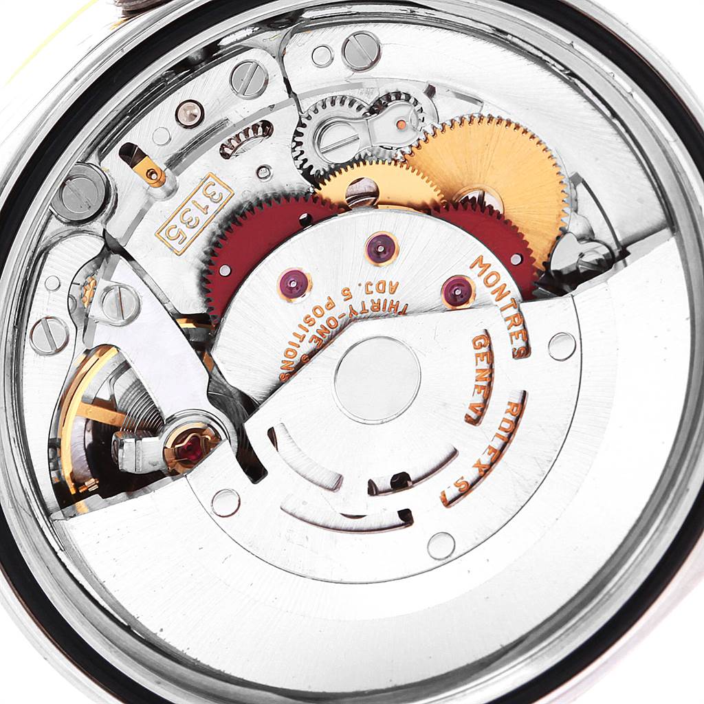 This image shows the movement mechanism of a Rolex Datejust 16233 Men's Steel and Gold (two tone) White Dial 16233 Men's Steel and Gold (two tone) White Dial watch, displaying gears, screws, and engravings from an internal angle.