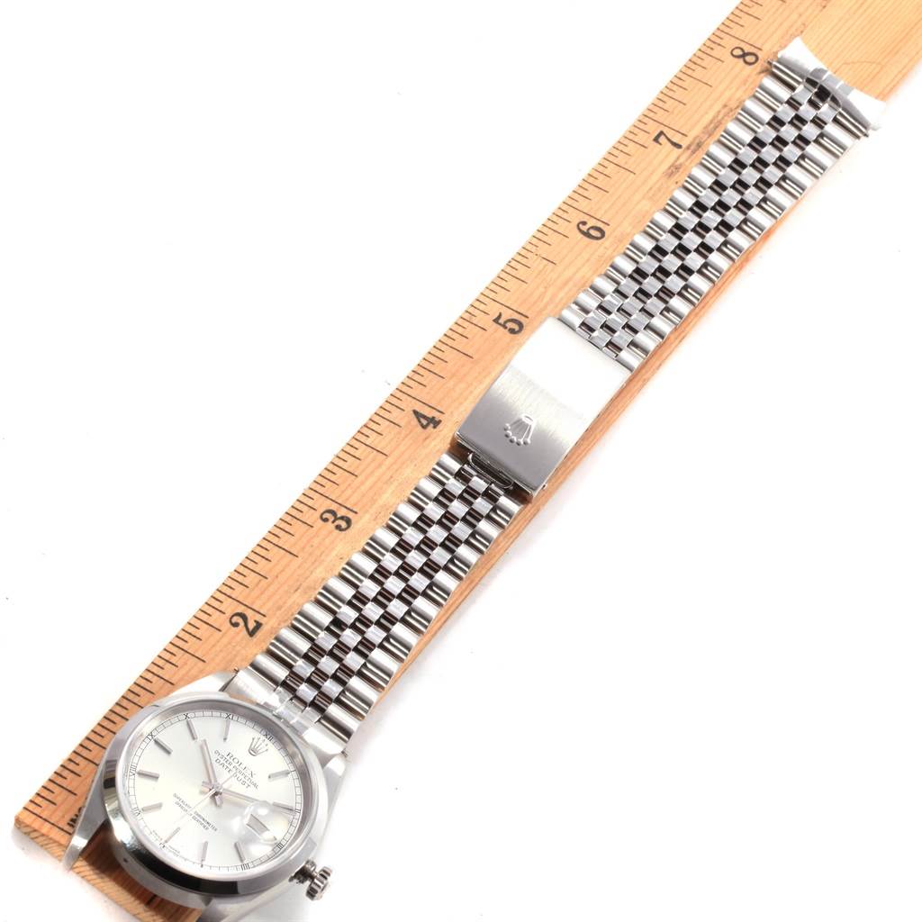 The Rolex Datejust 16200 Men's Stainless Steel Silver Dial 16200 Men's Stainless Steel Silver Dial watch is displayed flat on its side, showing the full length with a ruler for scale.