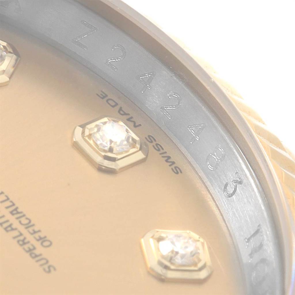The image shows a close-up of the dial and part of the casing of a Rolex Datejust 116233 Men's Stainless Steel Champagne Dial 116233 Men's Stainless Steel Champagne Dial watch, revealing some diamonds and text.
