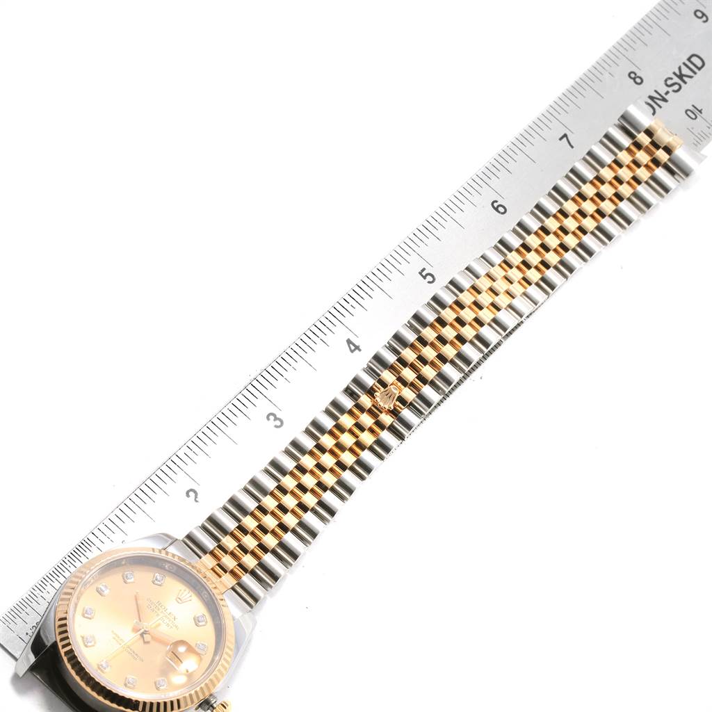 The image shows a Rolex Datejust 116233 Men's Stainless Steel Champagne Dial 116233 Men's Stainless Steel Champagne Dial watch laid flat with a focus on the bracelet, partially measured against a ruler.