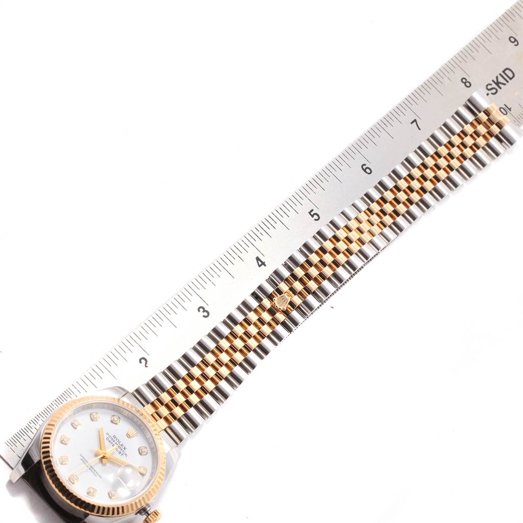 The image shows a Rolex Datejust 116233 Men's Stainless Steel White Dial 116233 Men's Stainless Steel White Dial watch with a two-tone bracelet and a fluted bezel, photographed from a top-down angle beside a ruler for scale.