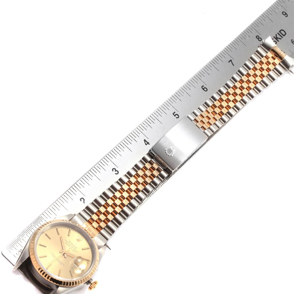 The image shows a Rolex Datejust 16233 Men's Steel and Gold (two tone) Champagne Dial 16233 Men's Steel and Gold (two tone) Champagne Dial watch laid flat with a stainless steel and gold bracelet, alongside a ruler.