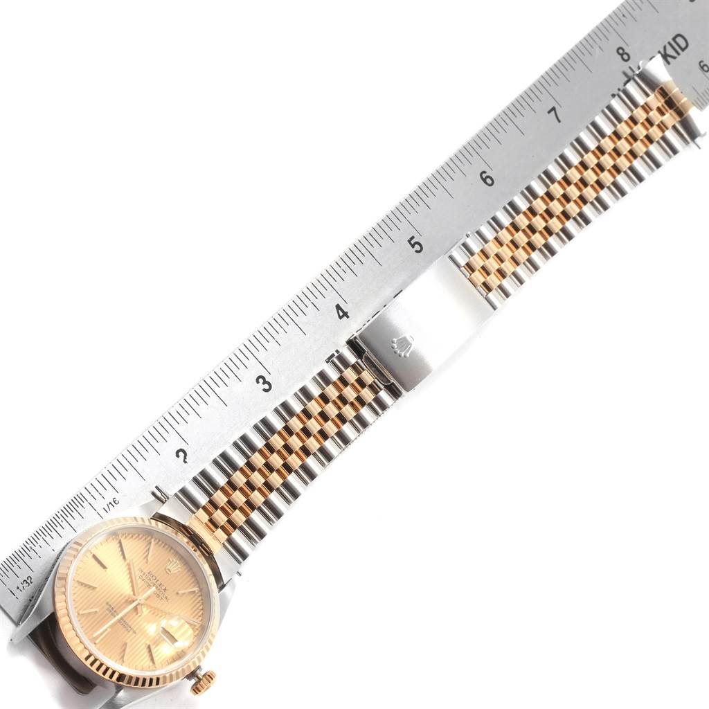 The image shows a Rolex Datejust 16233 Men's Steel and Gold (two tone) Champagne Dial 16233 Men's Steel and Gold (two tone) Champagne Dial watch horizontally, highlighting its bracelet and clasp against a ruler for scale.