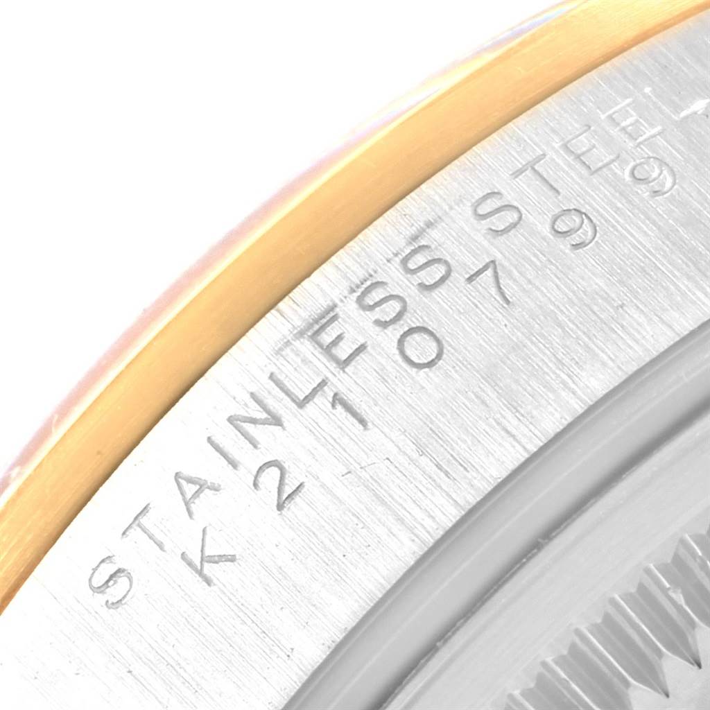 This image shows a close-up of the case back engraving and edge of the bezel of a Rolex Datejust 15203 Men's Steel and Gold (two tone) White Dial 15203 Men's Steel and Gold (two tone) White Dial watch.