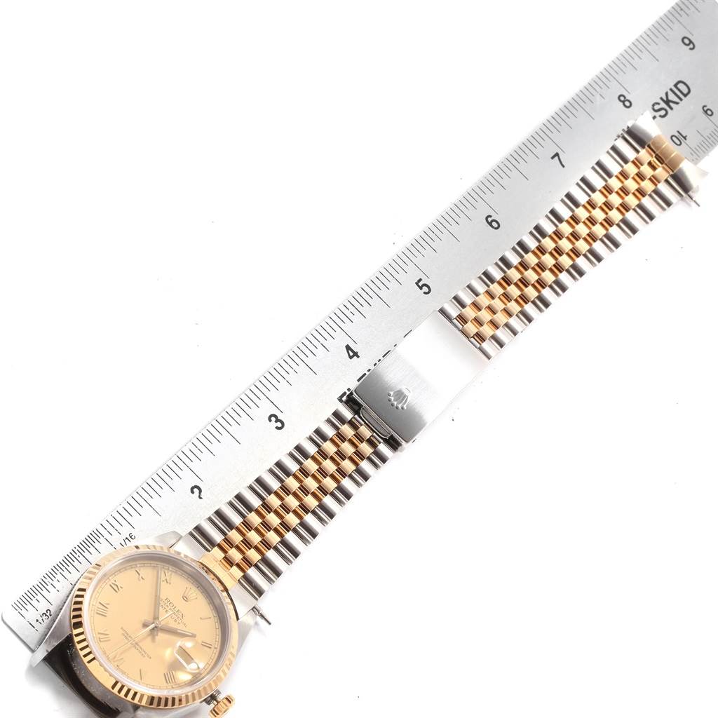 The image shows a Rolex Datejust 16233 Men's Steel and Gold (two tone) Champagne Dial 16233 Men's Steel and Gold (two tone) Champagne Dial watch laid flat next to a ruler, highlighting its face and metal link bracelet.