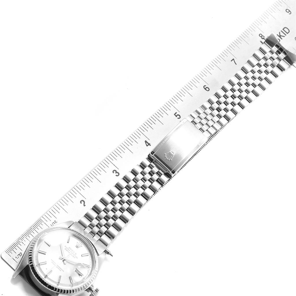 The image shows a top view of a Rolex Datejust 1601 Men
s Stainless Steel Silver Dial 1601 Men
s Stainless Steel Silver Dial watch and its stainless steel bracelet measured with a ruler.
