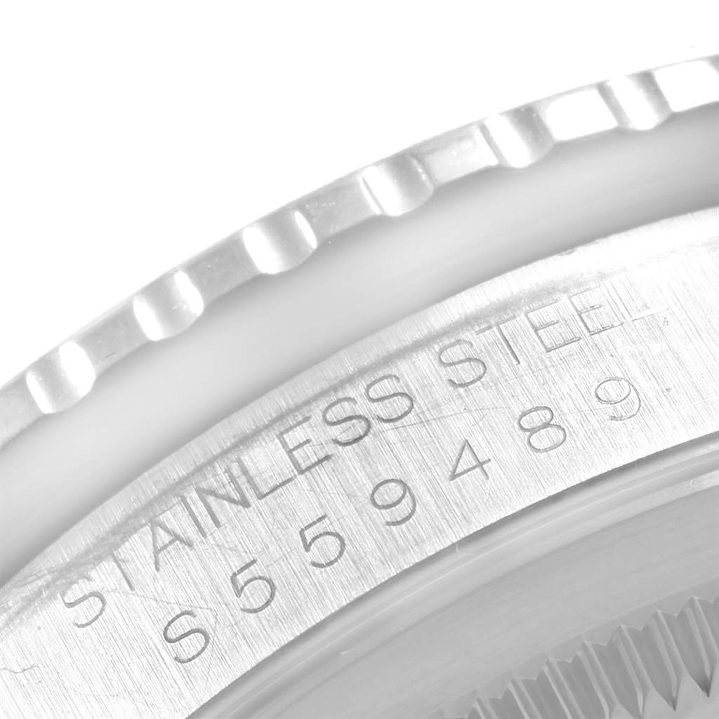 This is a close-up of the Rolex Datejust 16264 Men's Stainless Steel Silver Dial 16264 Men's Stainless Steel Silver Dial watch bezel and part of the stainless steel case with engraved serial numbers.