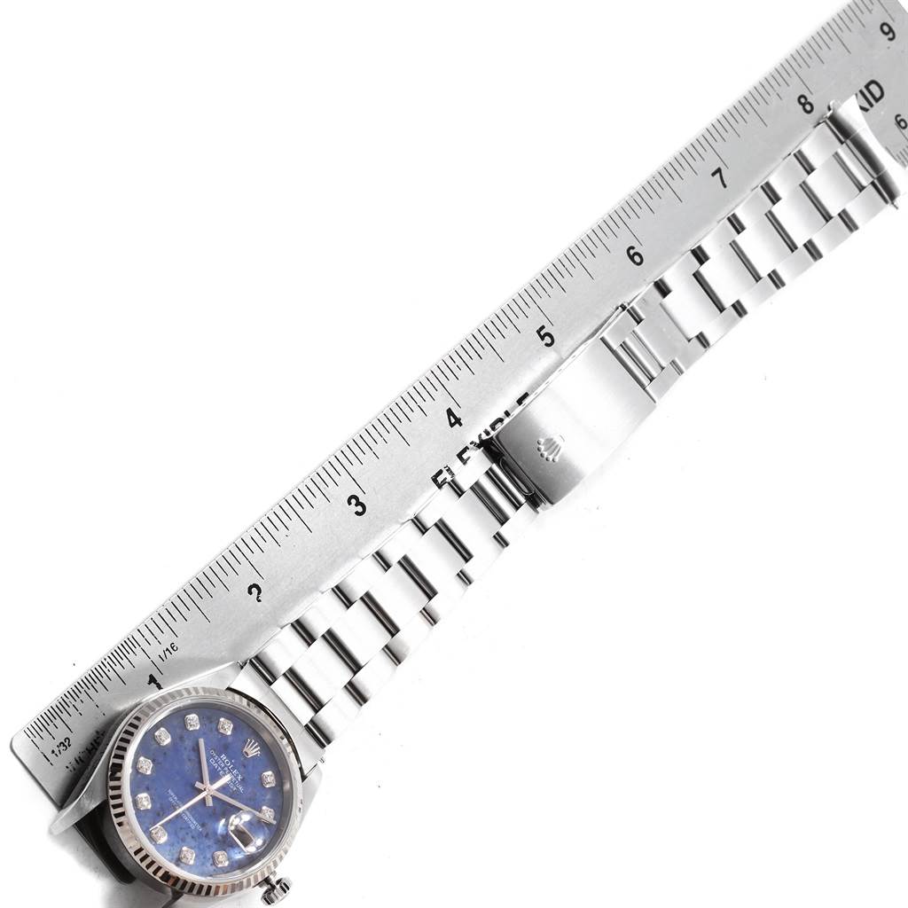 The image shows a Rolex Datejust 16234 Men
s Stainless Steel Blue Dial 16234 Men
s Stainless Steel Blue Dial watch face and its metal bracelet, measured against a ruler.