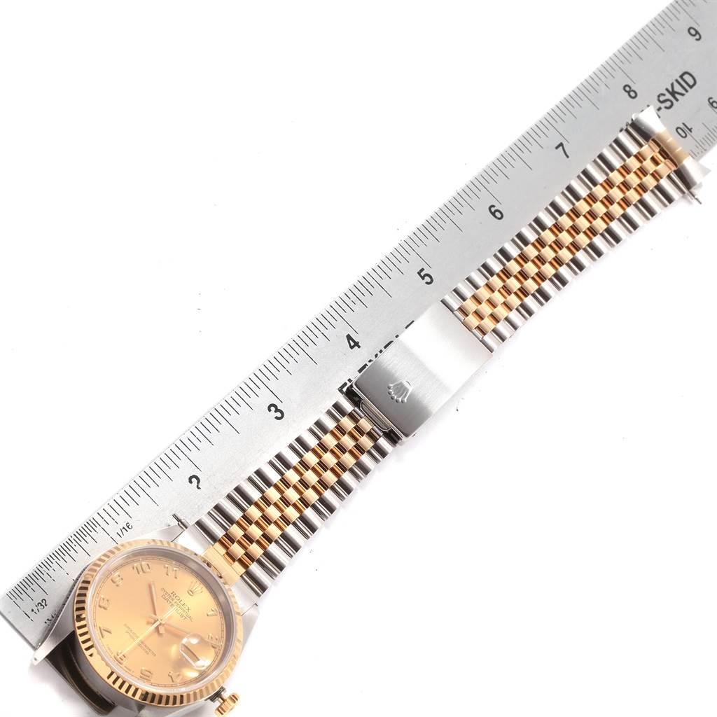 The image shows a Rolex Datejust 16233 Men's Steel and Gold (two tone) Champagne Dial 16233 Men's Steel and Gold (two tone) Champagne Dial watch laid flat next to a ruler, highlighting its bracelet and clasp.