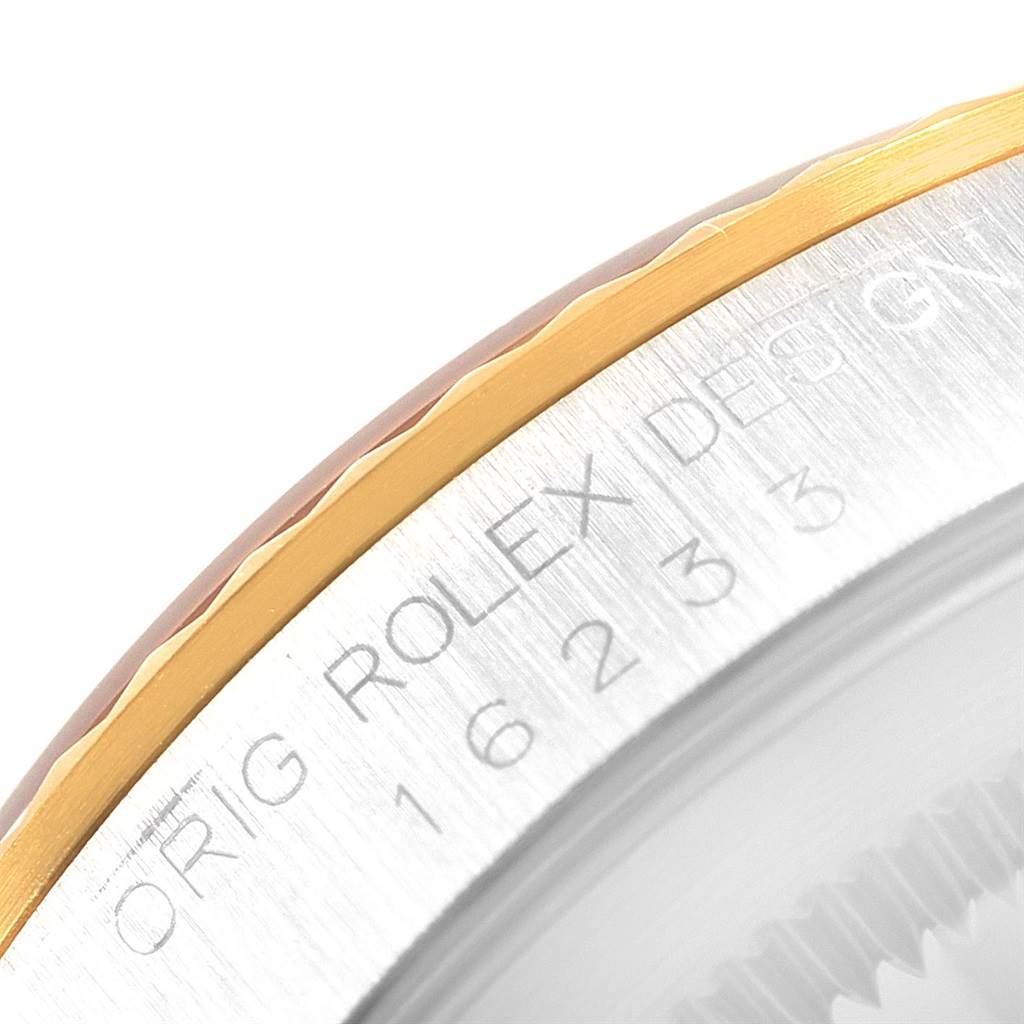The image shows a close-up of the engraved edge and fluted bezel of a Rolex Datejust 16233 Men's Steel and Gold (two tone) Champagne Dial 16233 Men's Steel and Gold (two tone) Champagne Dial watch.